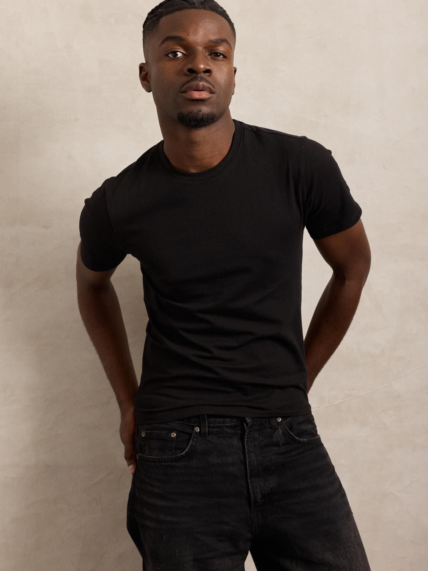 Graël en t-shirt noir, séance studio sur fond beige