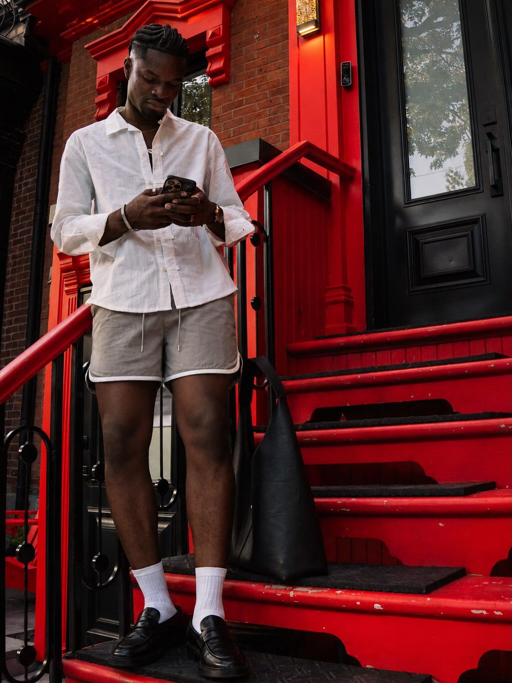 Graël sur un escalier rouge, téléphone en main