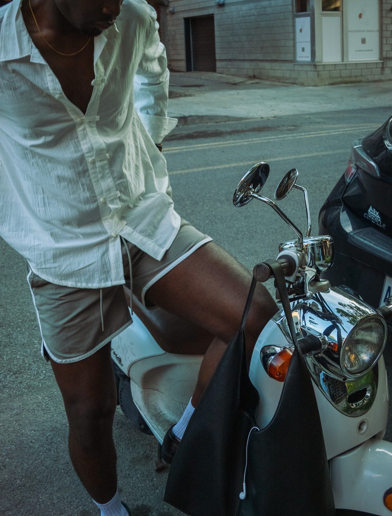 Détail : chemise blanche et scooter