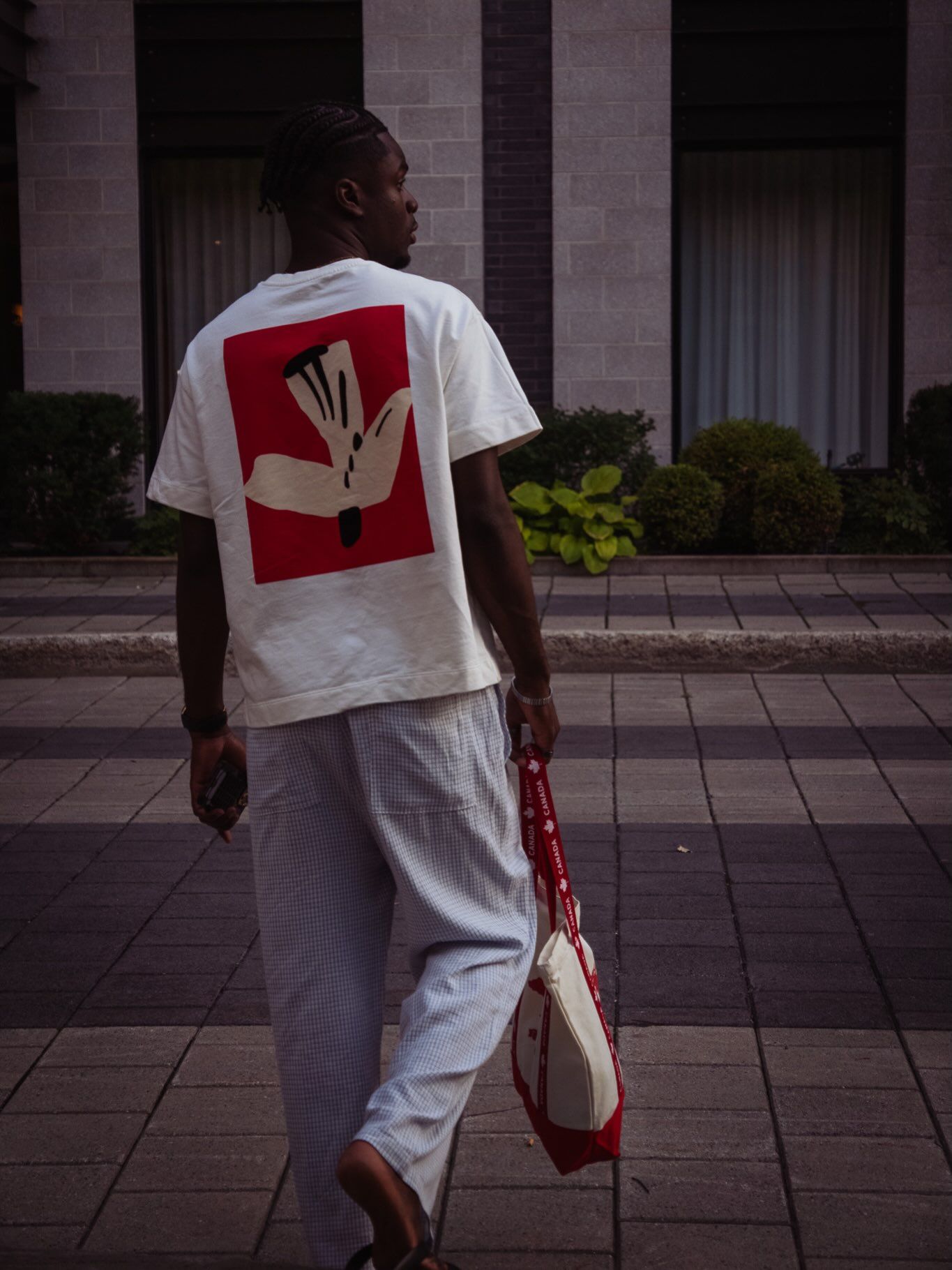 Graël de dos, t-shirt blanc à imprimé rouge, sac en toile